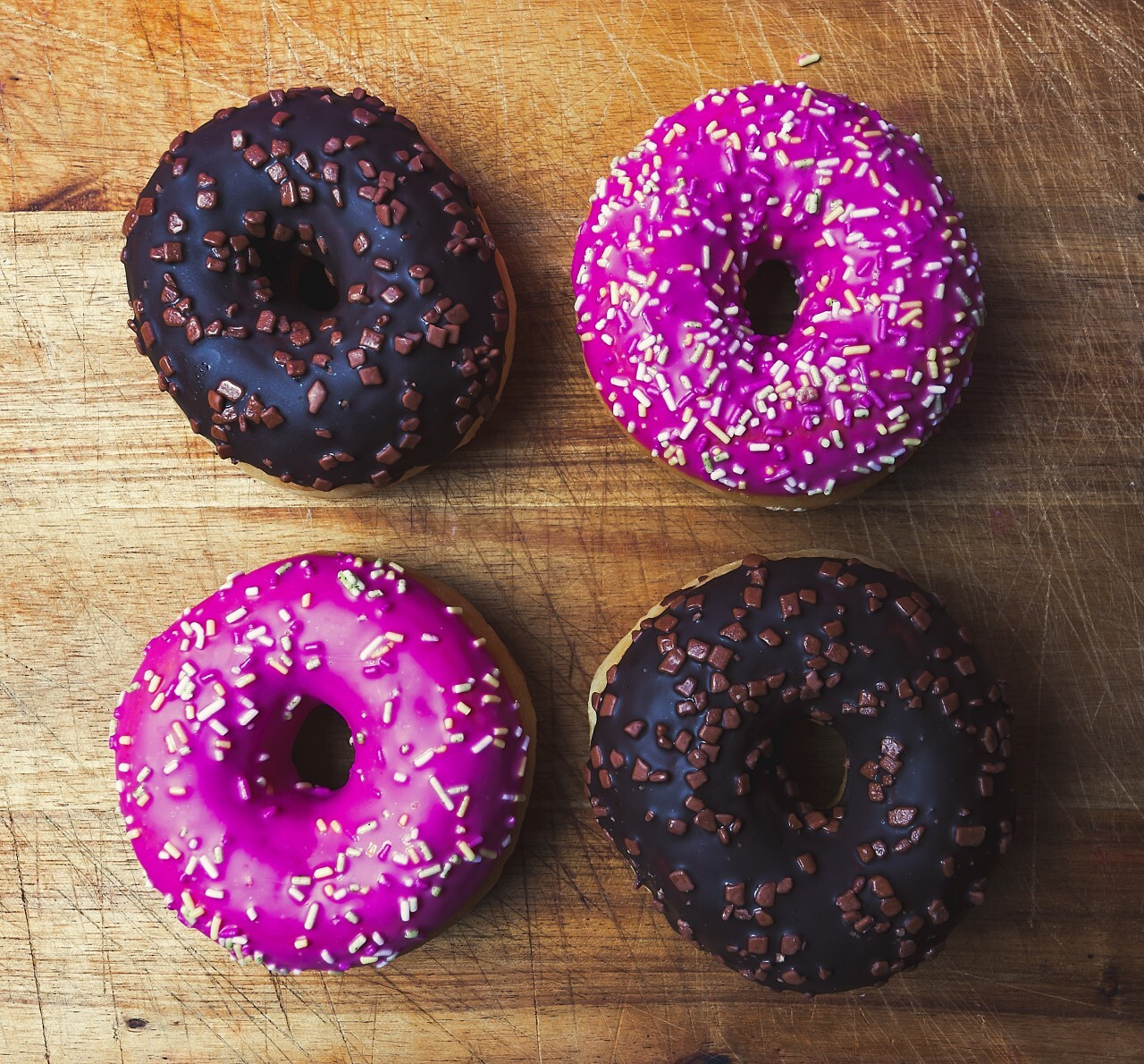 two chocolate donuts and two pink donuts