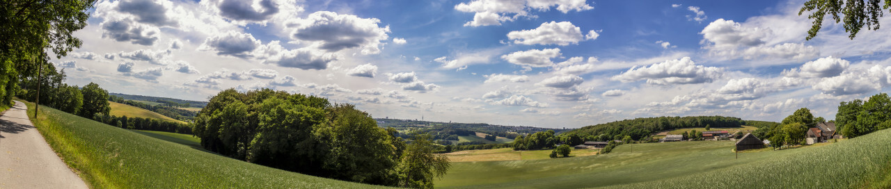 Super Panorama of a Beautiful rural landscape in Germany with blue sky, impressive clouds and a wonderful little farm