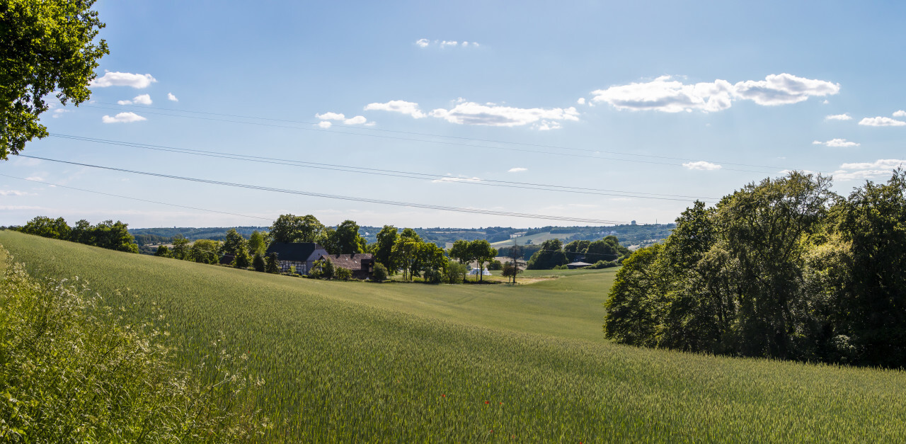 German rural landscape near Velbert Langenberg with fields and hills and a Farm in Background