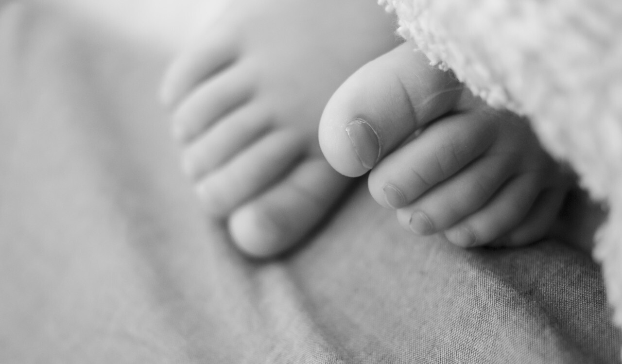 A toddler's toes peek out from under the blanket
