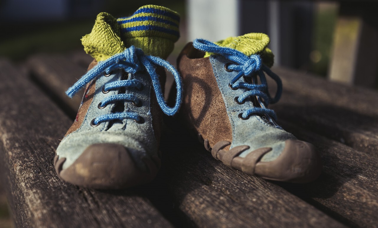 childrens shoes on a park bench