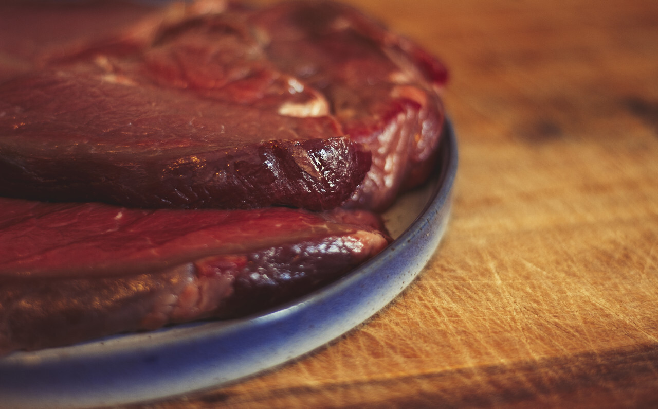 raw beef steaks on a plate