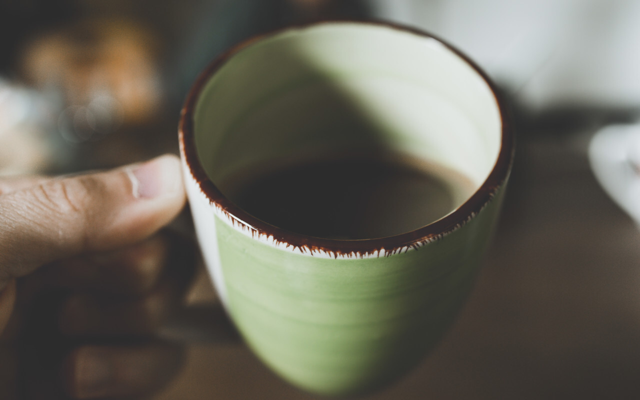 Male hands holding cup of coffee