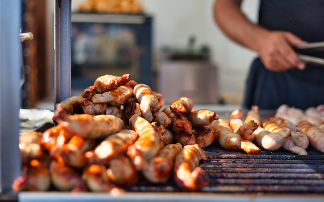 Lots of grilled sausages on a grill - street food stand