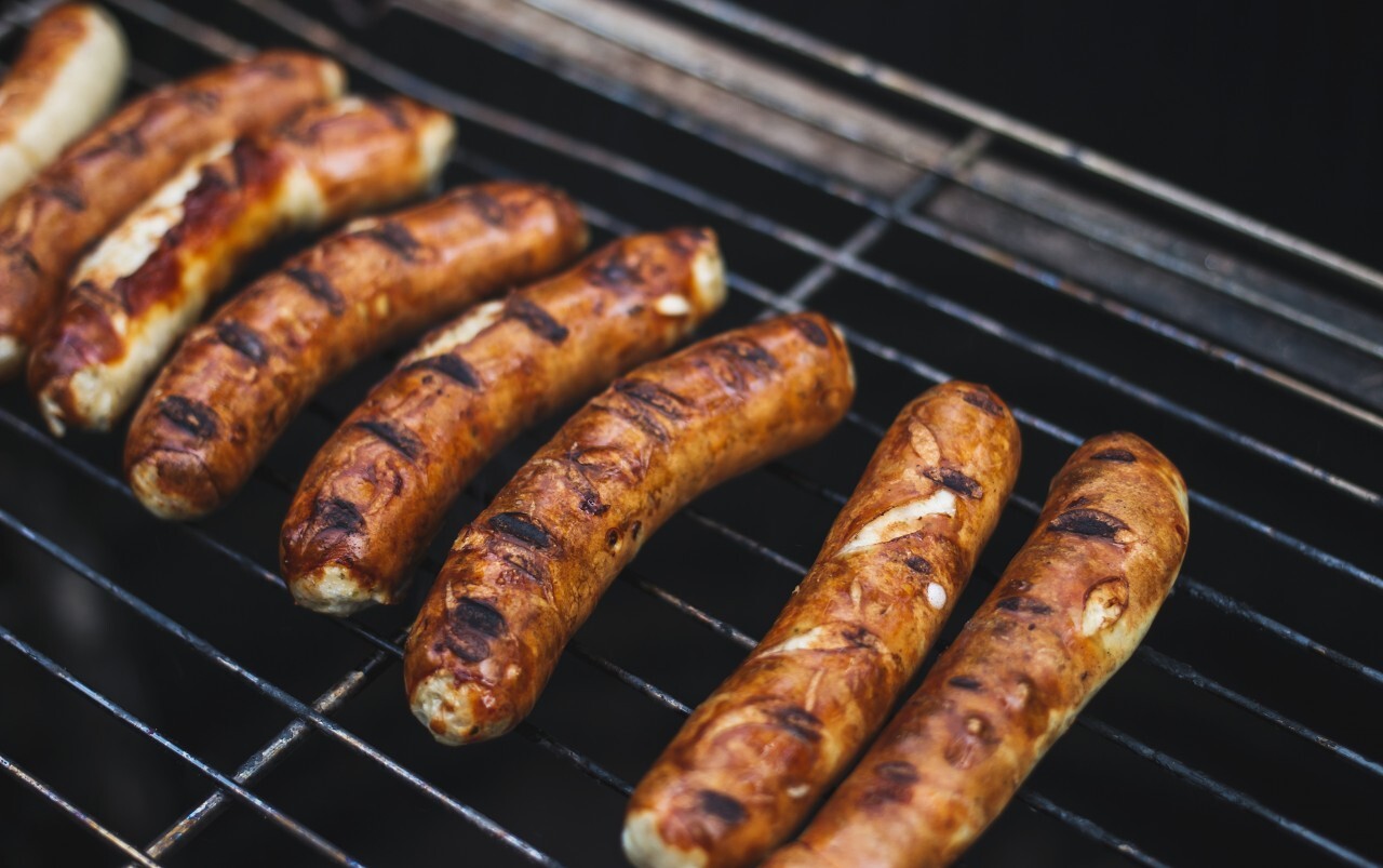 Grilling sausages on barbecue grill