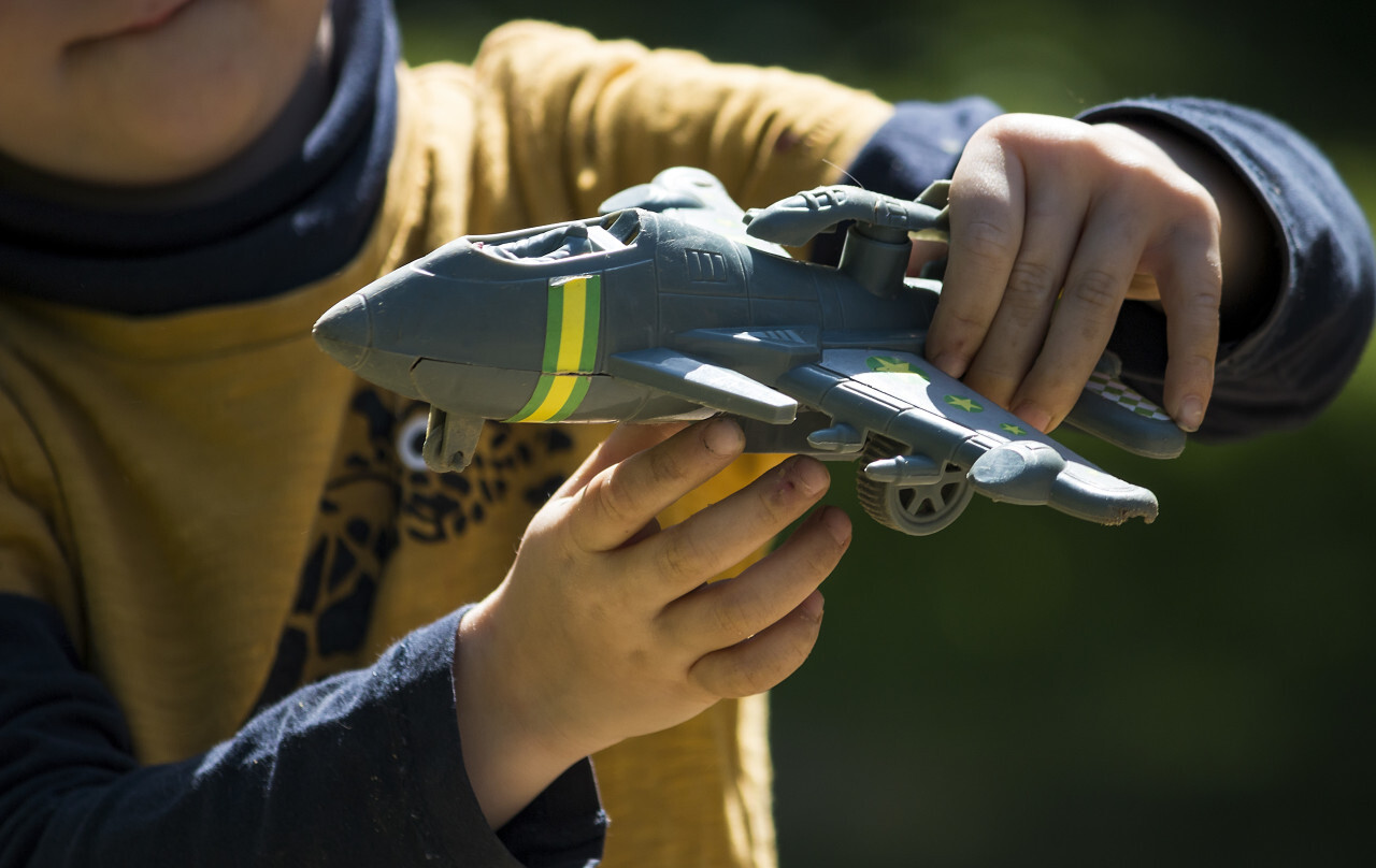 child plays with toy warplane