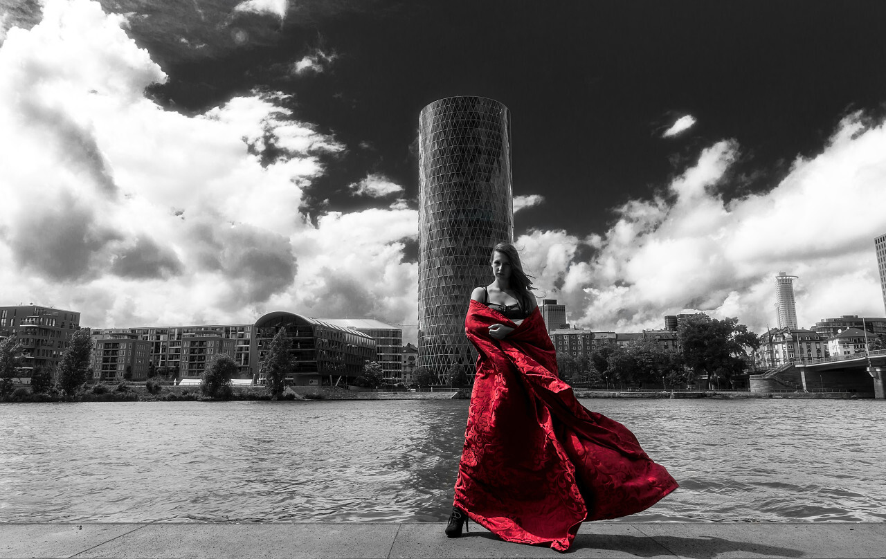 Young woman in red dress by a river
