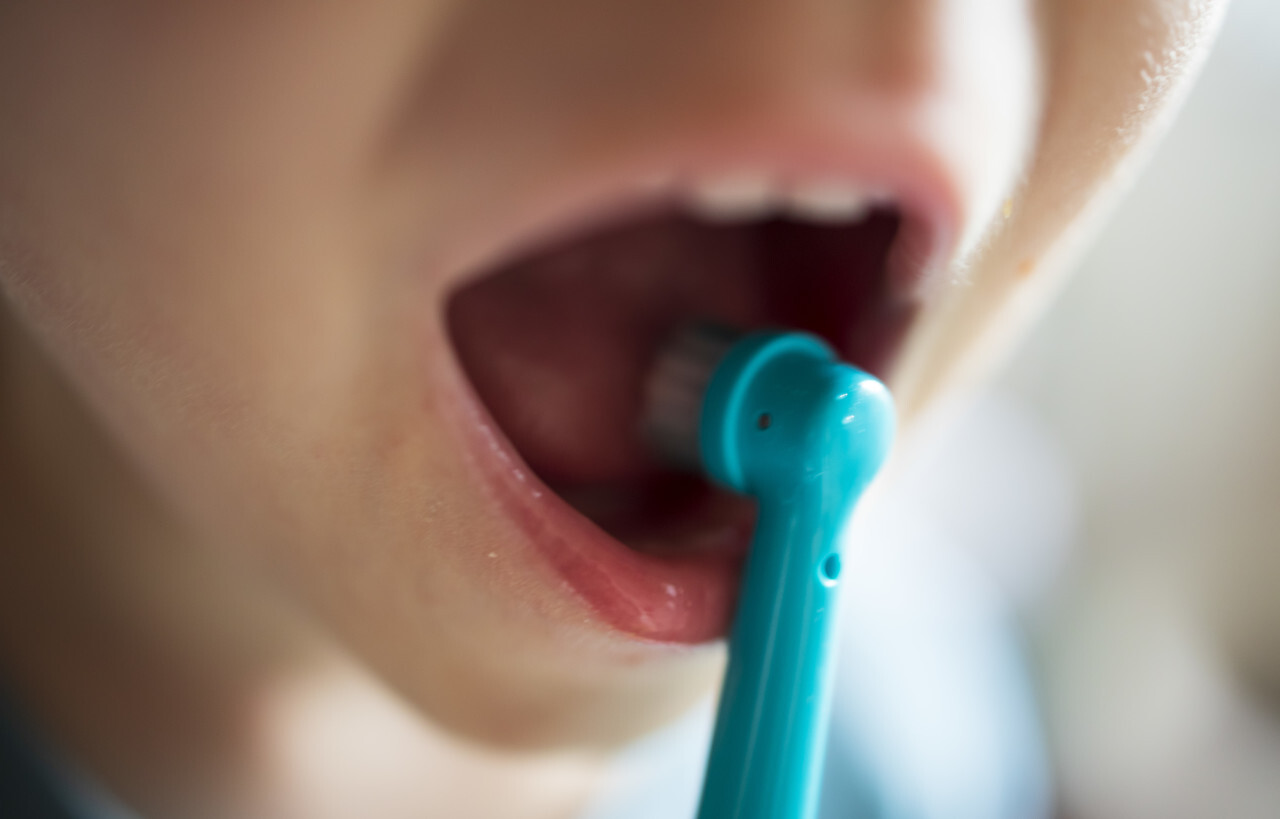 Child with electric toothbrush in his mouth