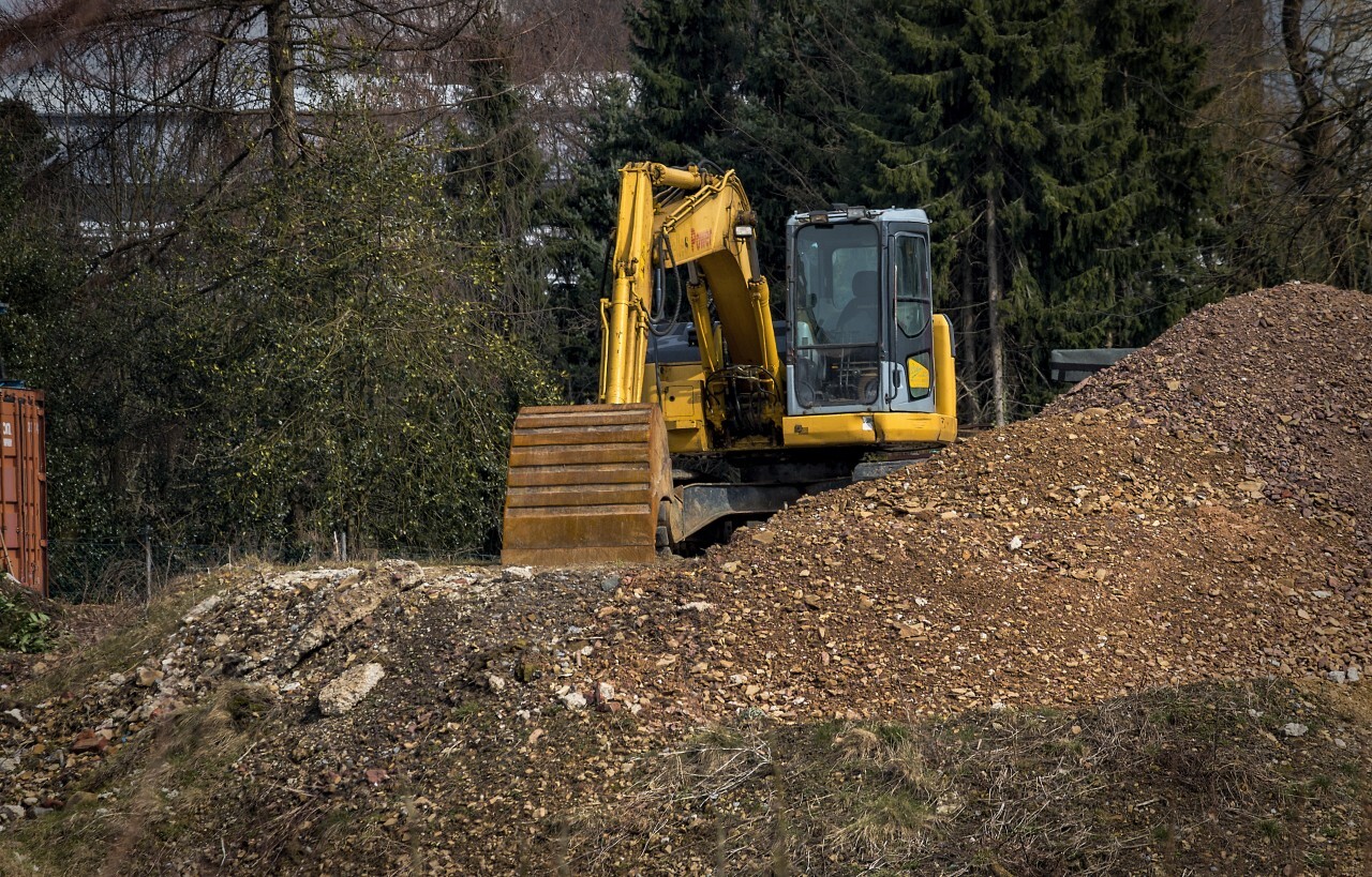 yellow excavator and a heap of earth