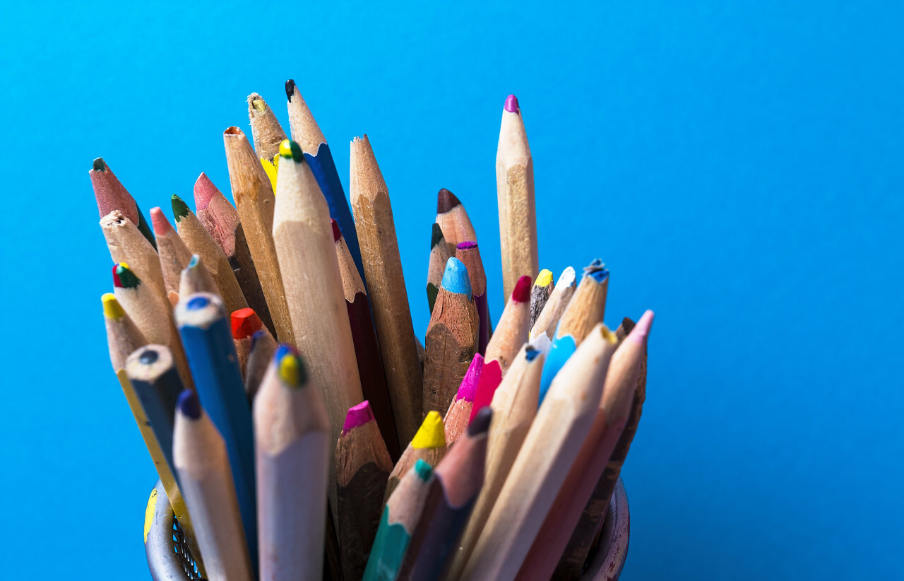 childrens color pencils on blue background