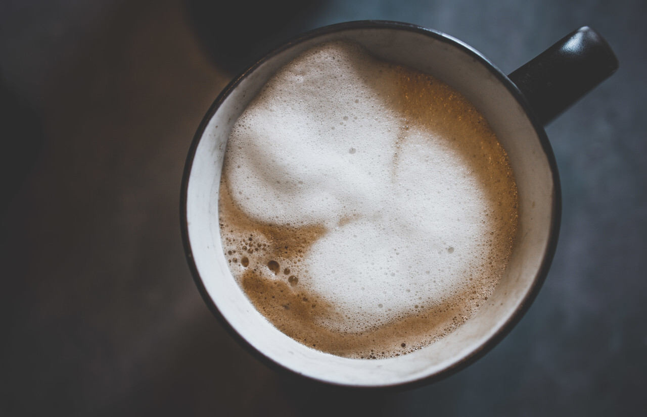 Cup of coffee with milk froth from above