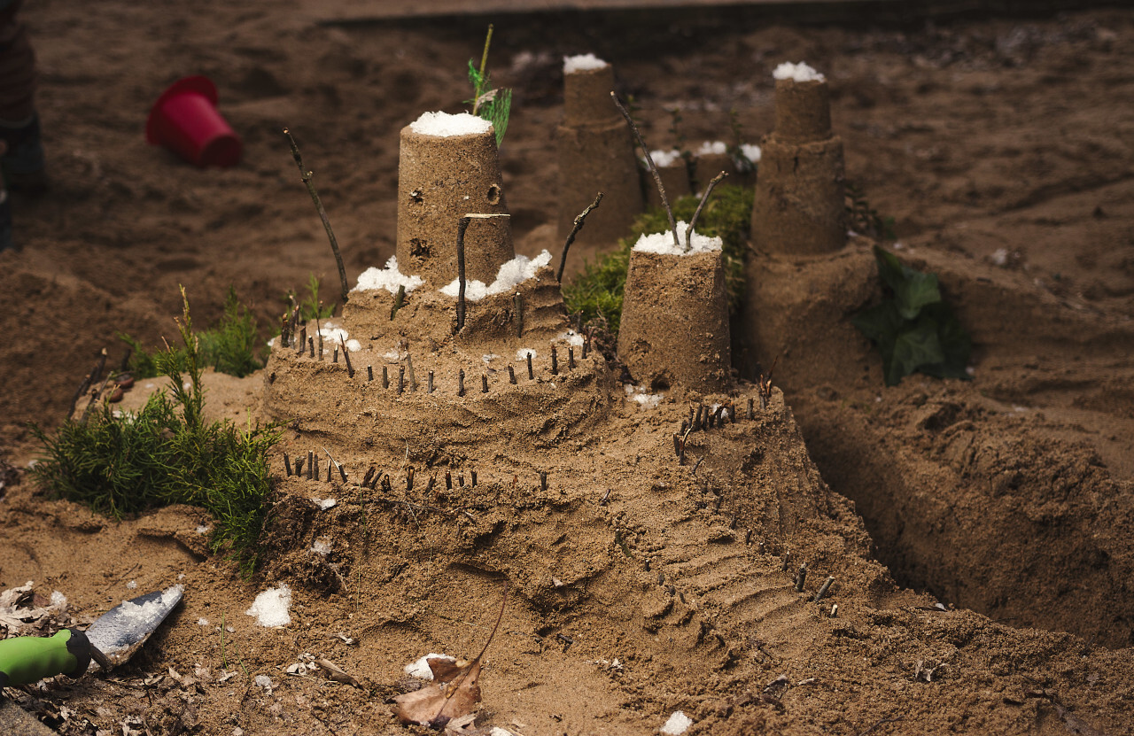 Children playing with sand building a castle