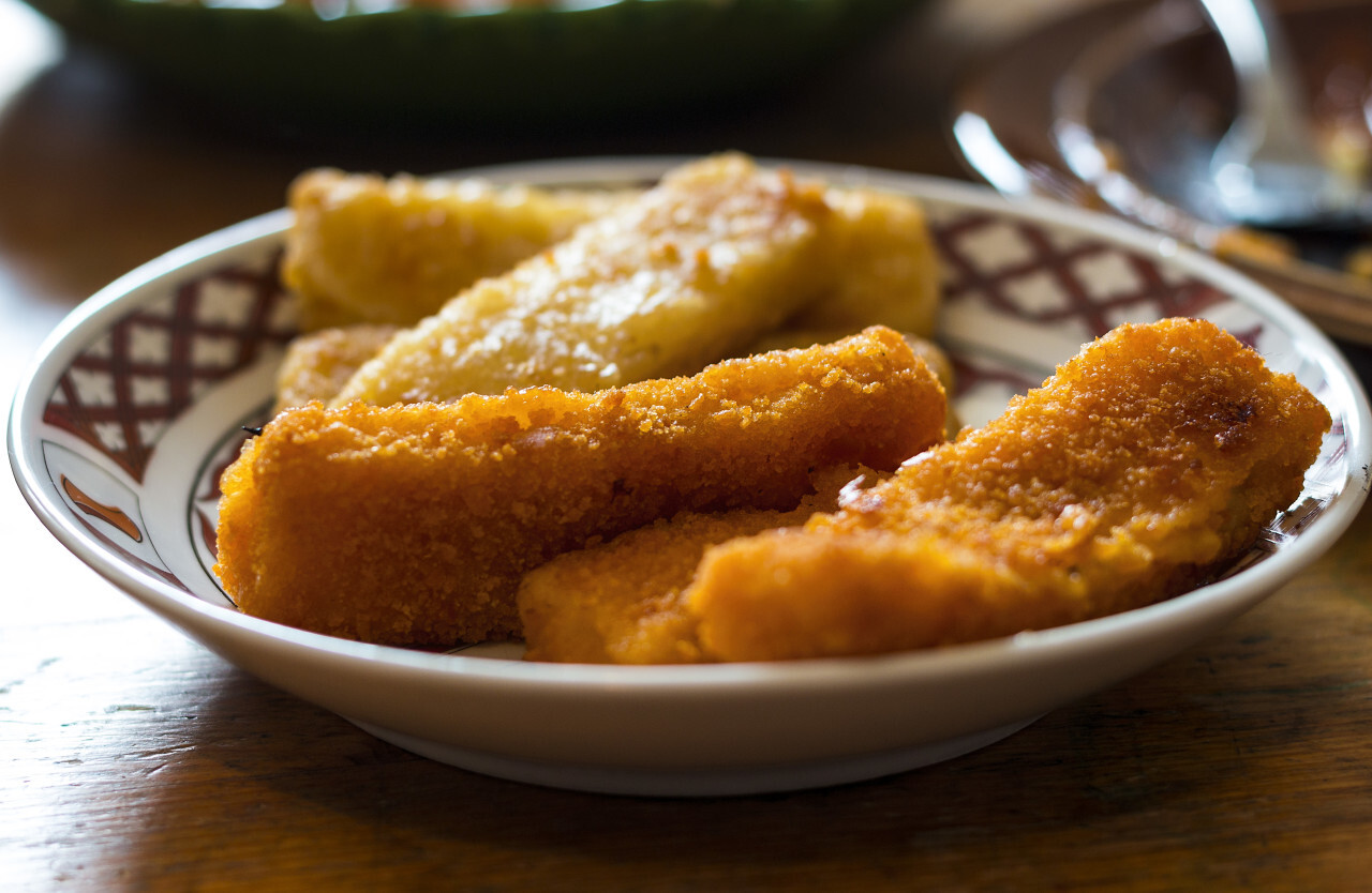 Fish fingers on a plate in a kitchen on a wooden table