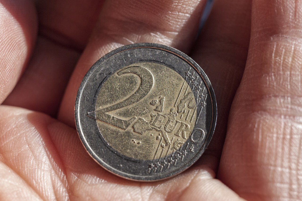 2 euro coin with scratches in hand