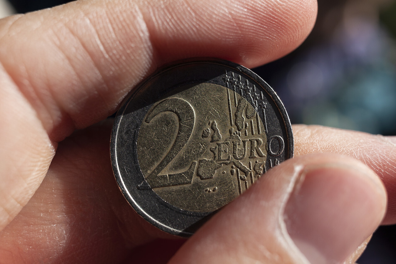 2 euro coin with scratches in hand