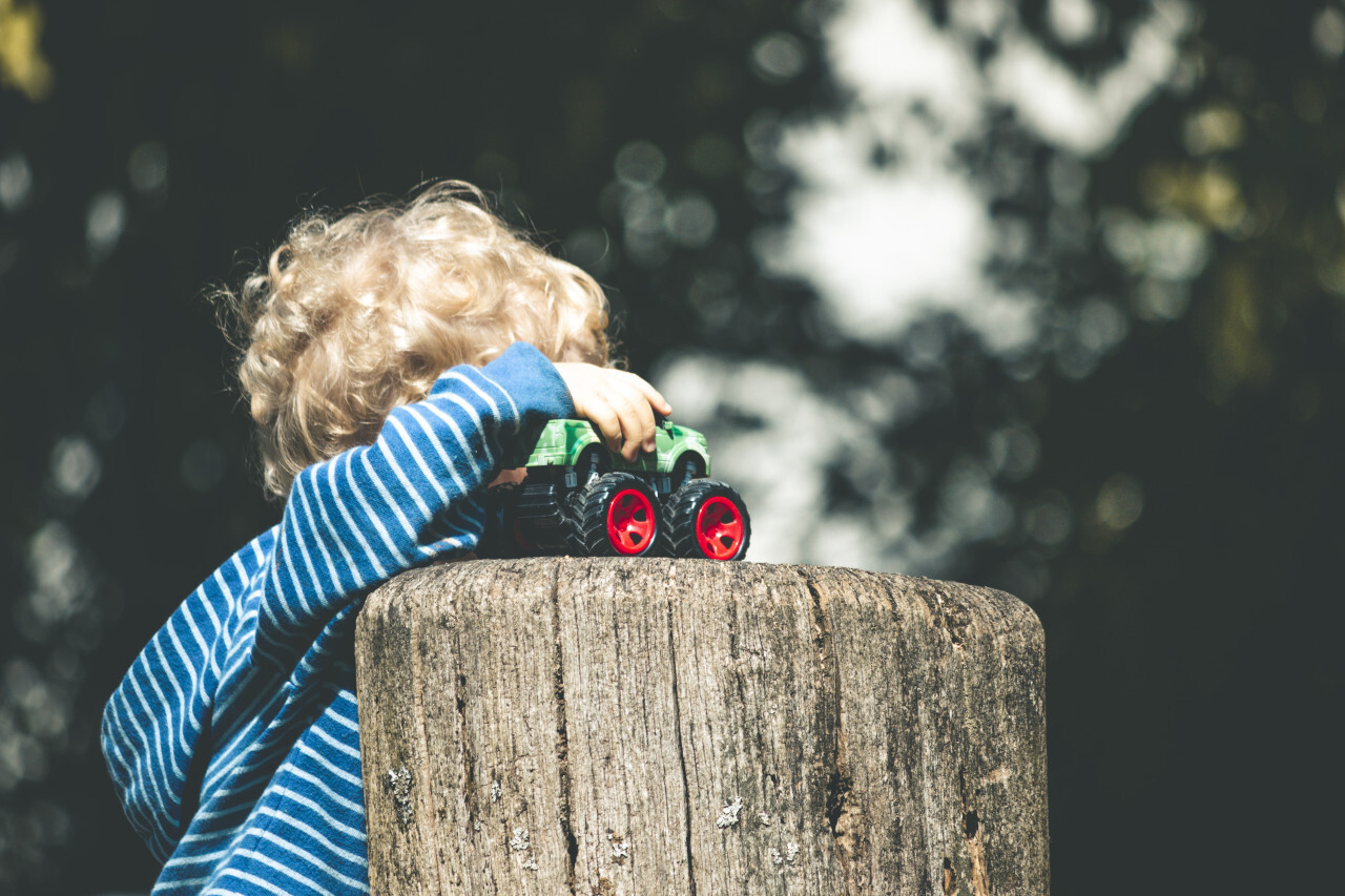 child plays with toy car