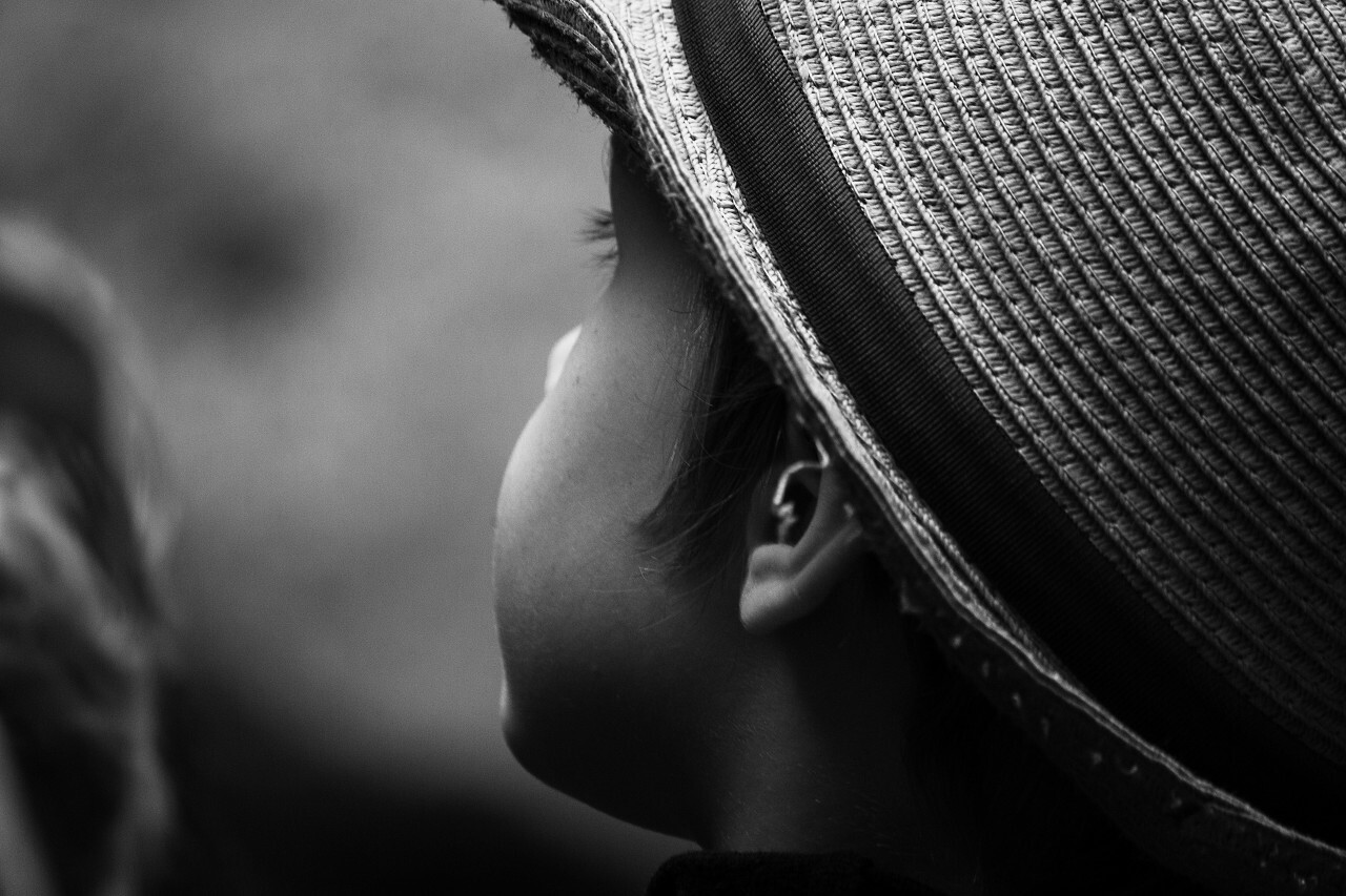 child with straw hat black and white