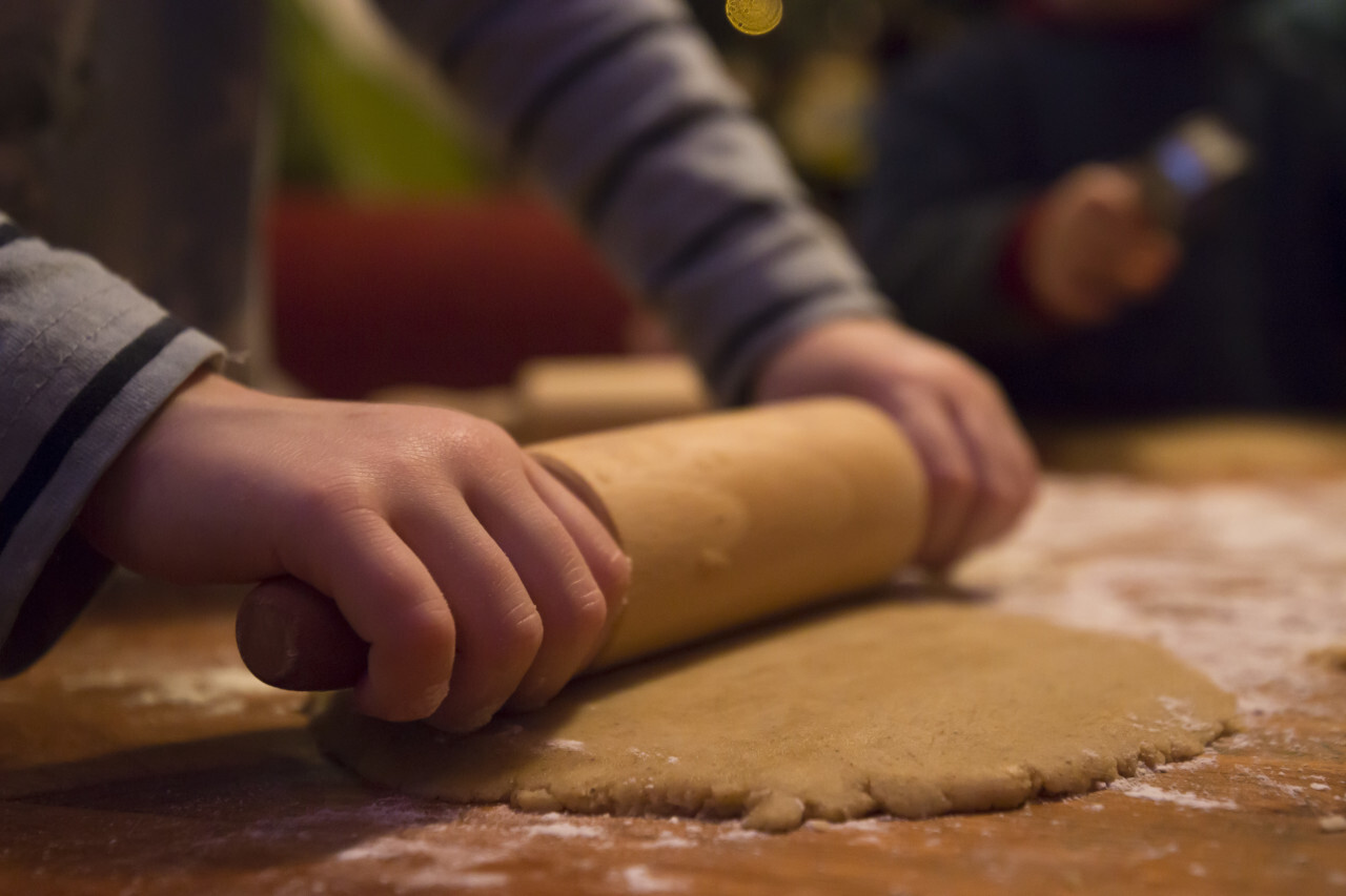 child rolls out biscuit