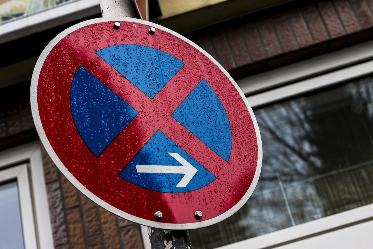 Round road sign with a red cross on a blue background. A sign means a parking prohibitio