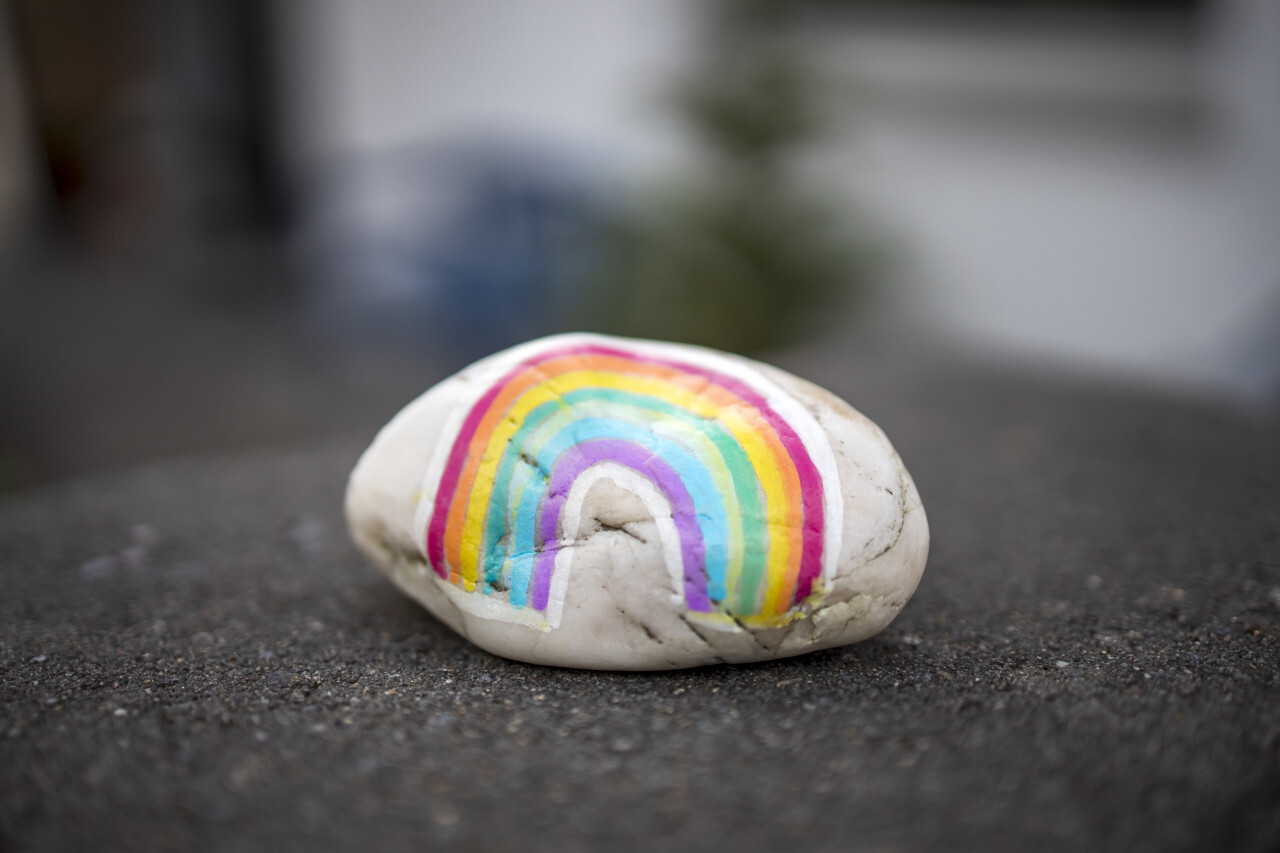 A stone on which a child painted a rainbow. Stay at home during Corona