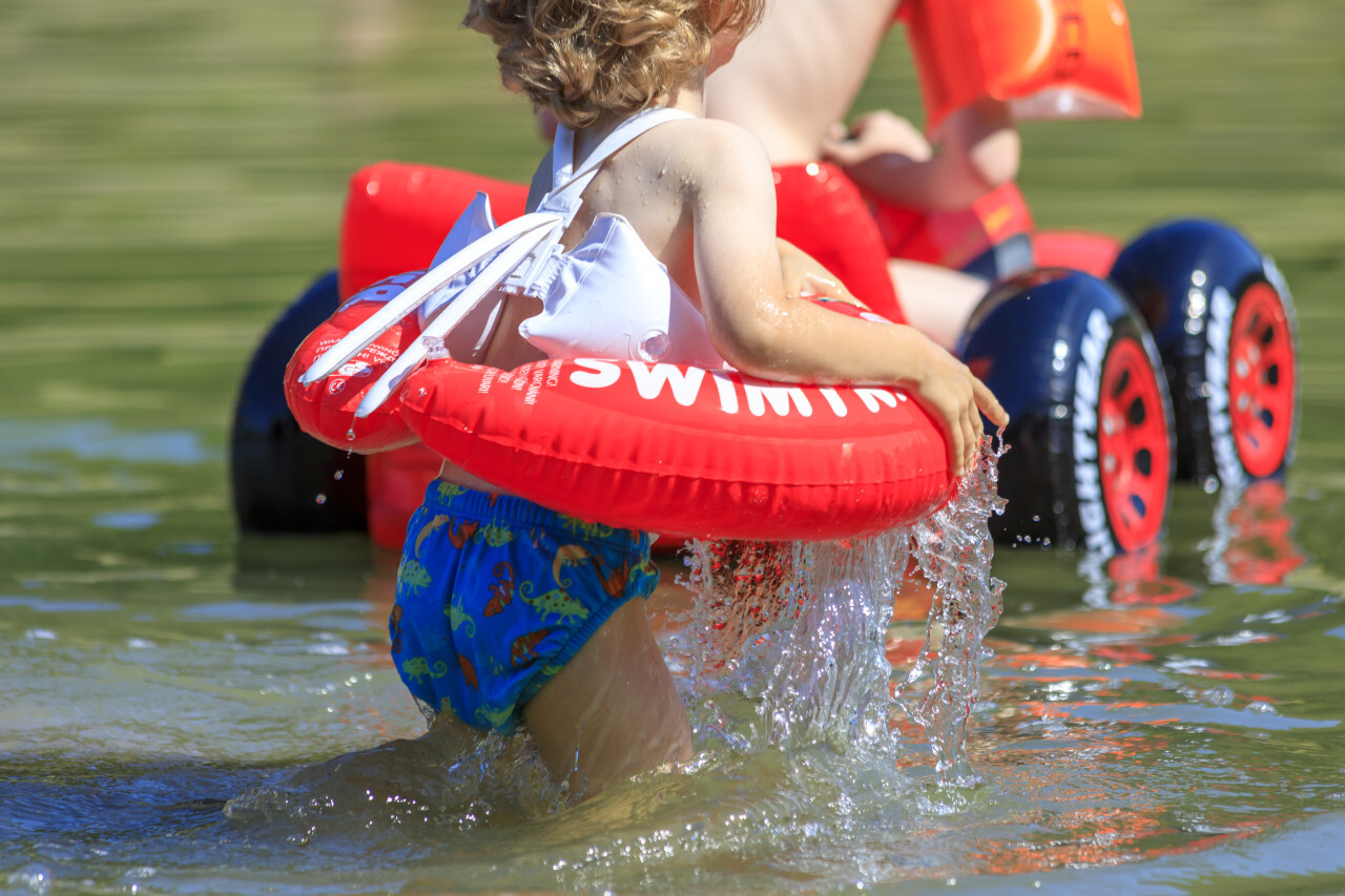 little boy playing in the water of a lake