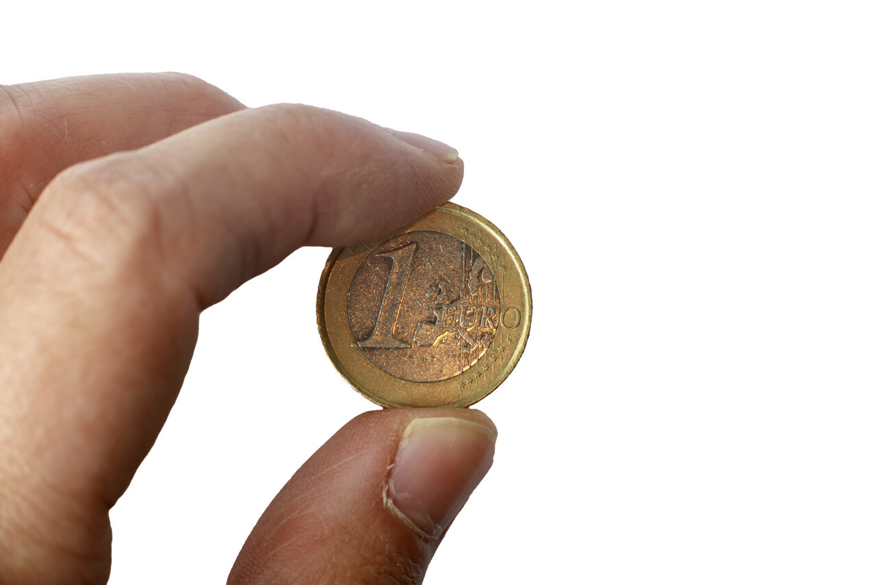 One euro coin in a hand isolated on a white background