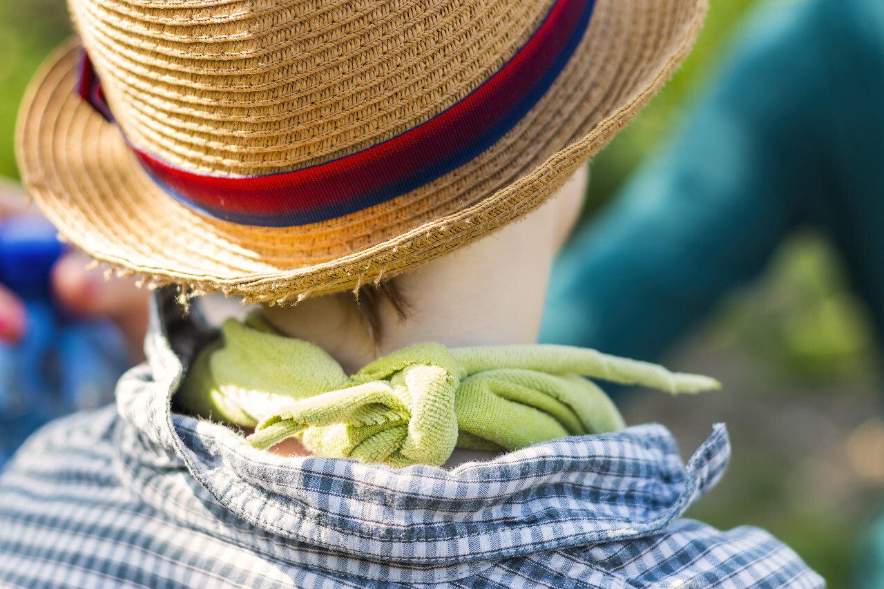 child with neckerchief and hat from behind