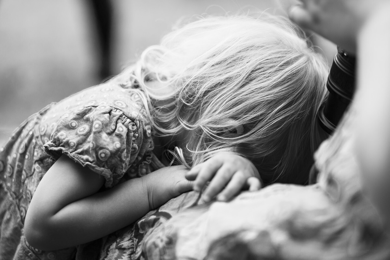 Little girl is crying herself on the shot of her parents