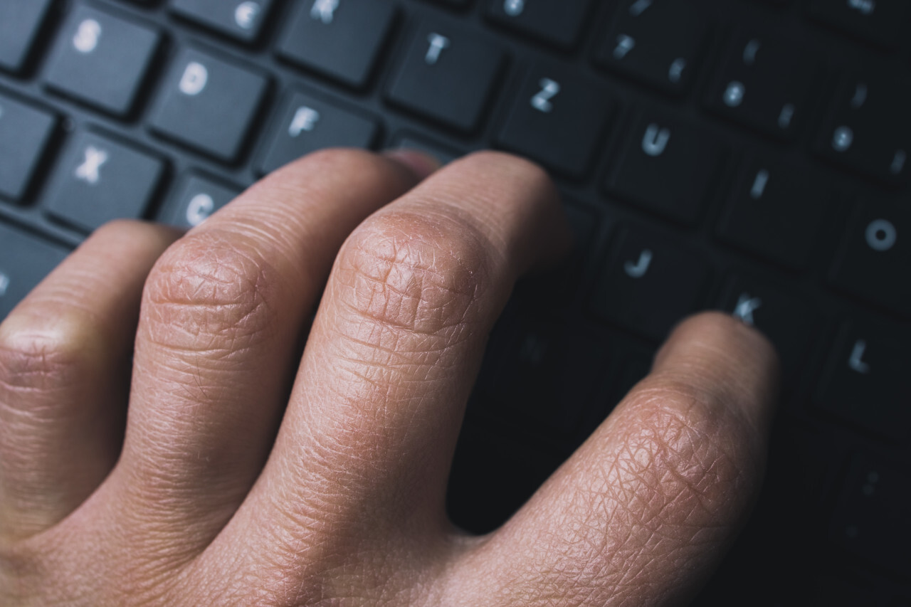 Male hands typing on computer keyboard