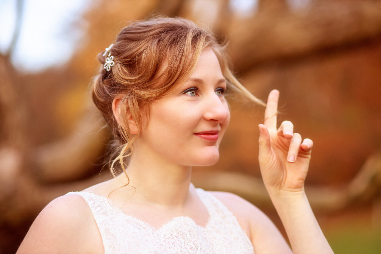 Young happy blonde bride playing with her hair