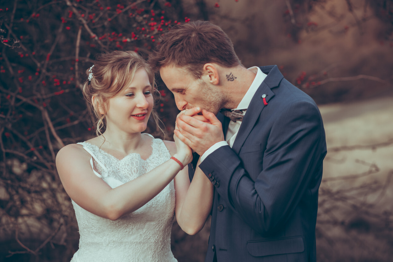 Husband kisses his wife's hand shortly after the wedding