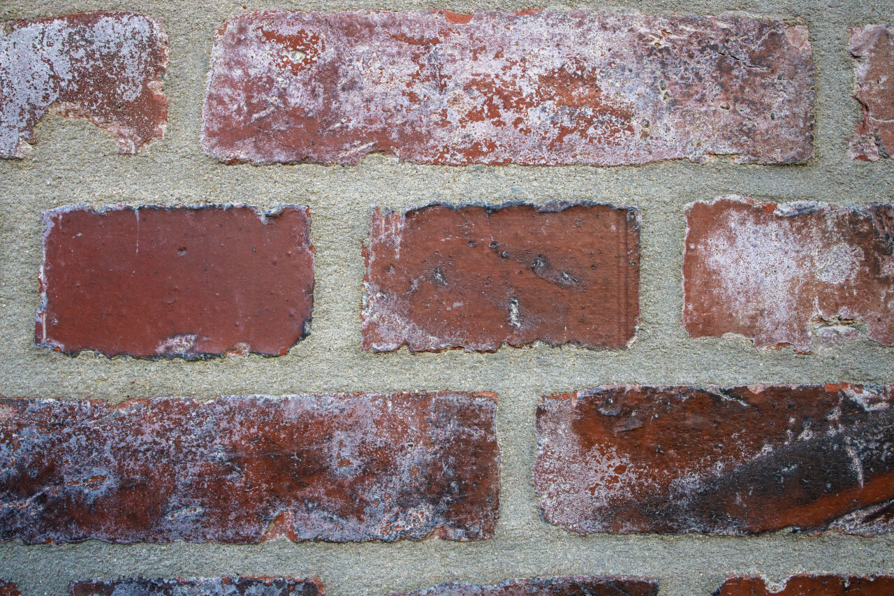 Weathered stained old brick wall