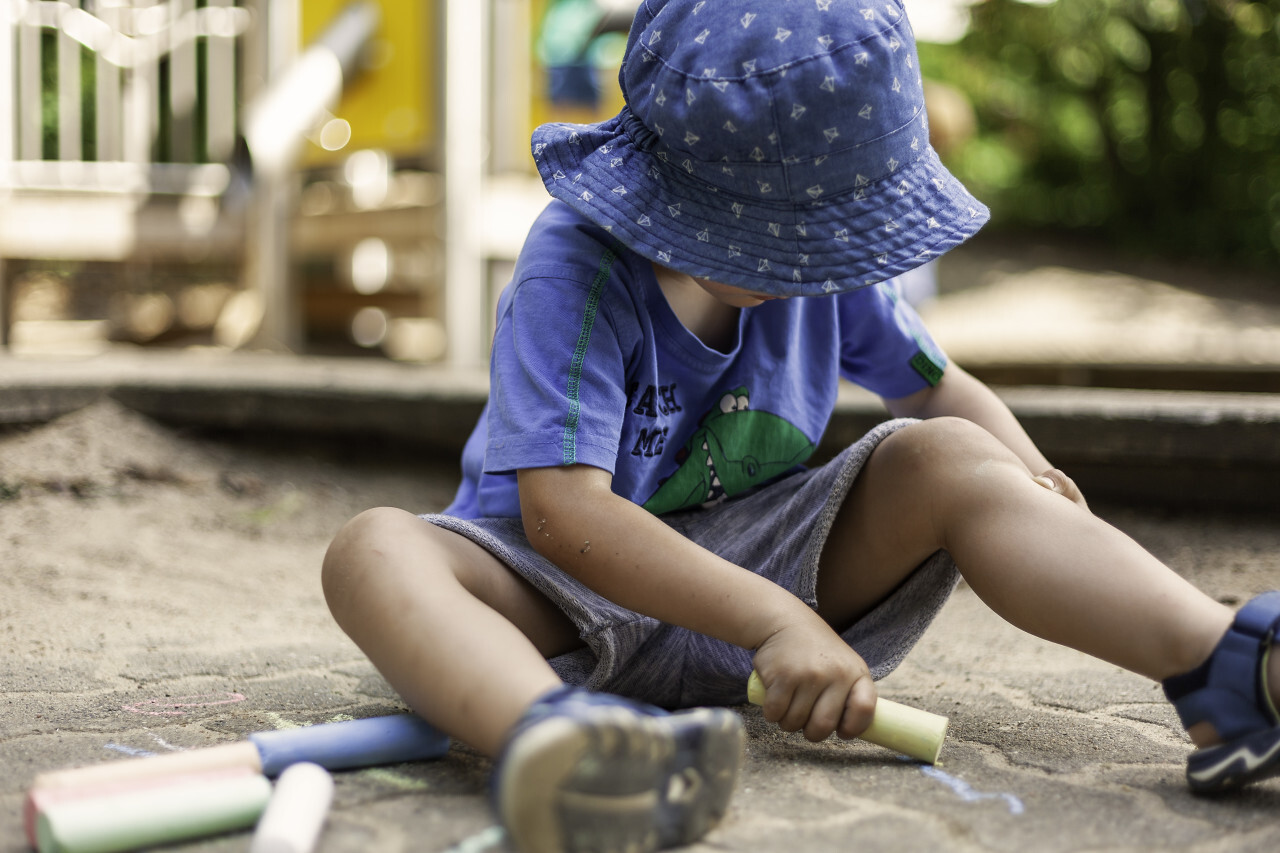 boy paints chalk on the pavement