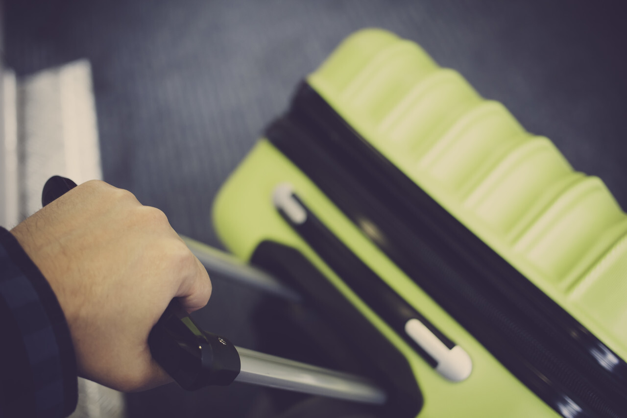 traveler with green suitcase