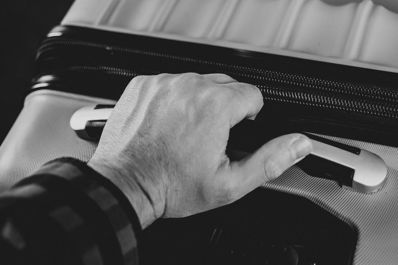 traveler with suitcase black and white