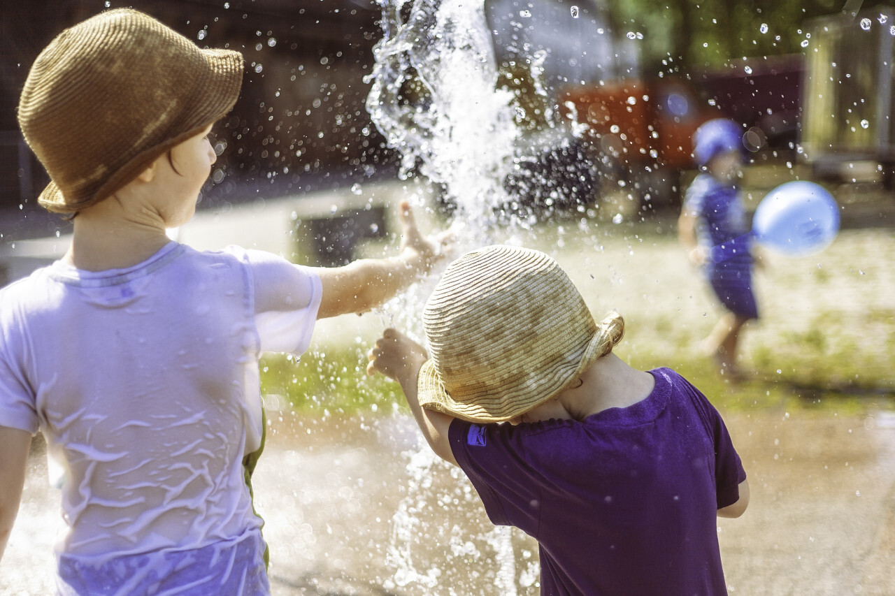 children play at the fountain summertime