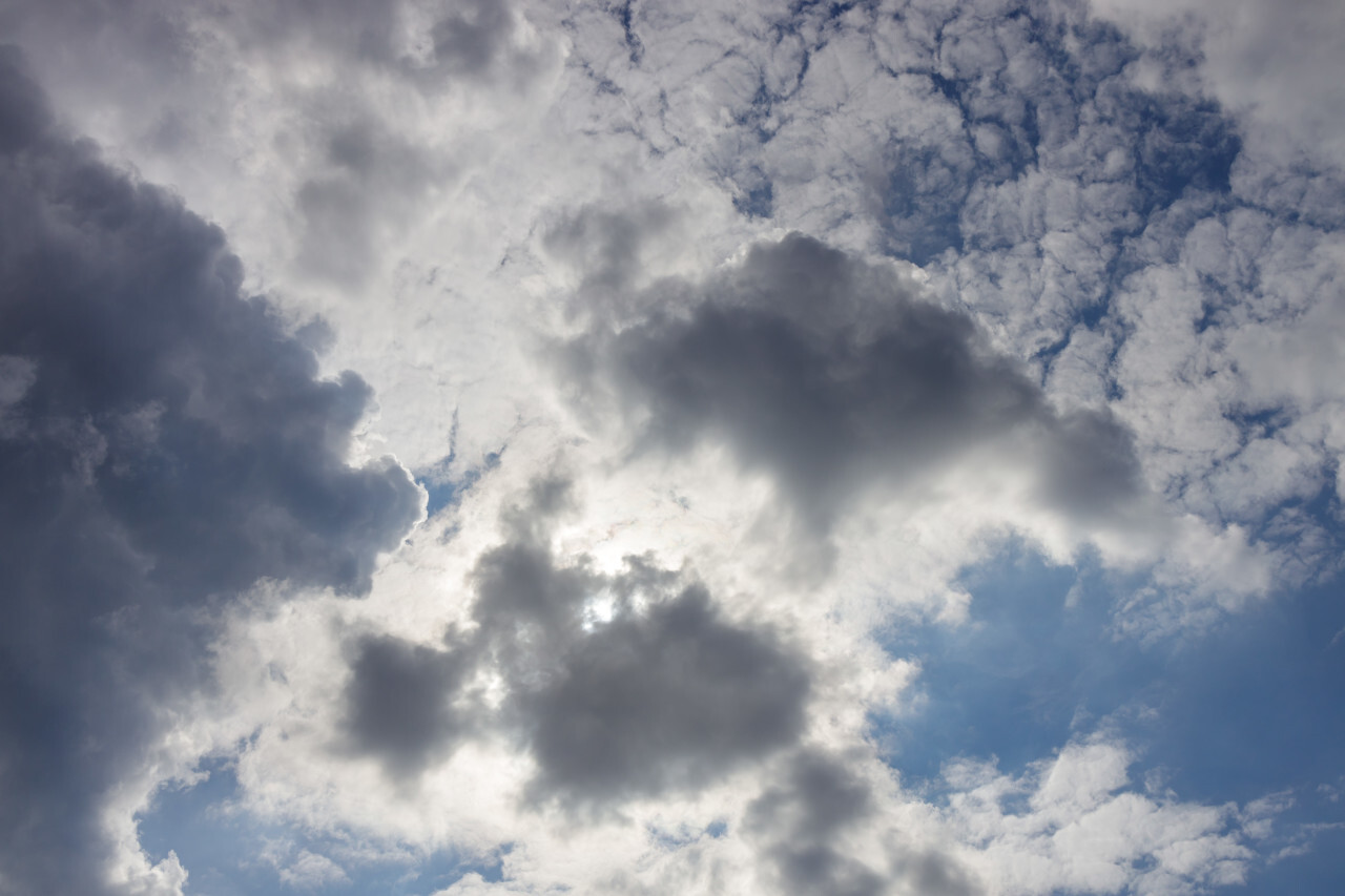 Sun behind white Clouds on a blue Sky for sky replacement