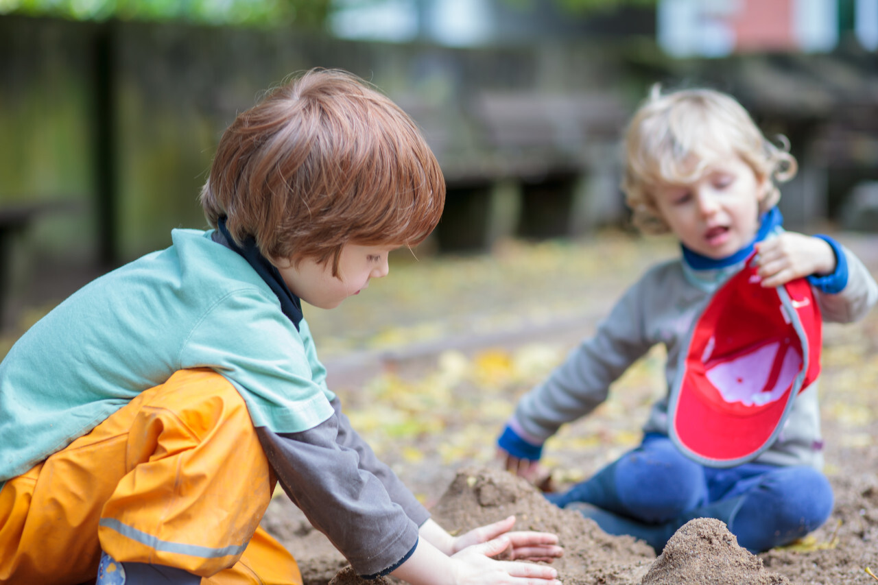 Brothers play in the sandpit