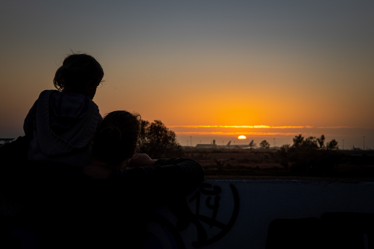 Mother and daughter watch the sunset on the beach