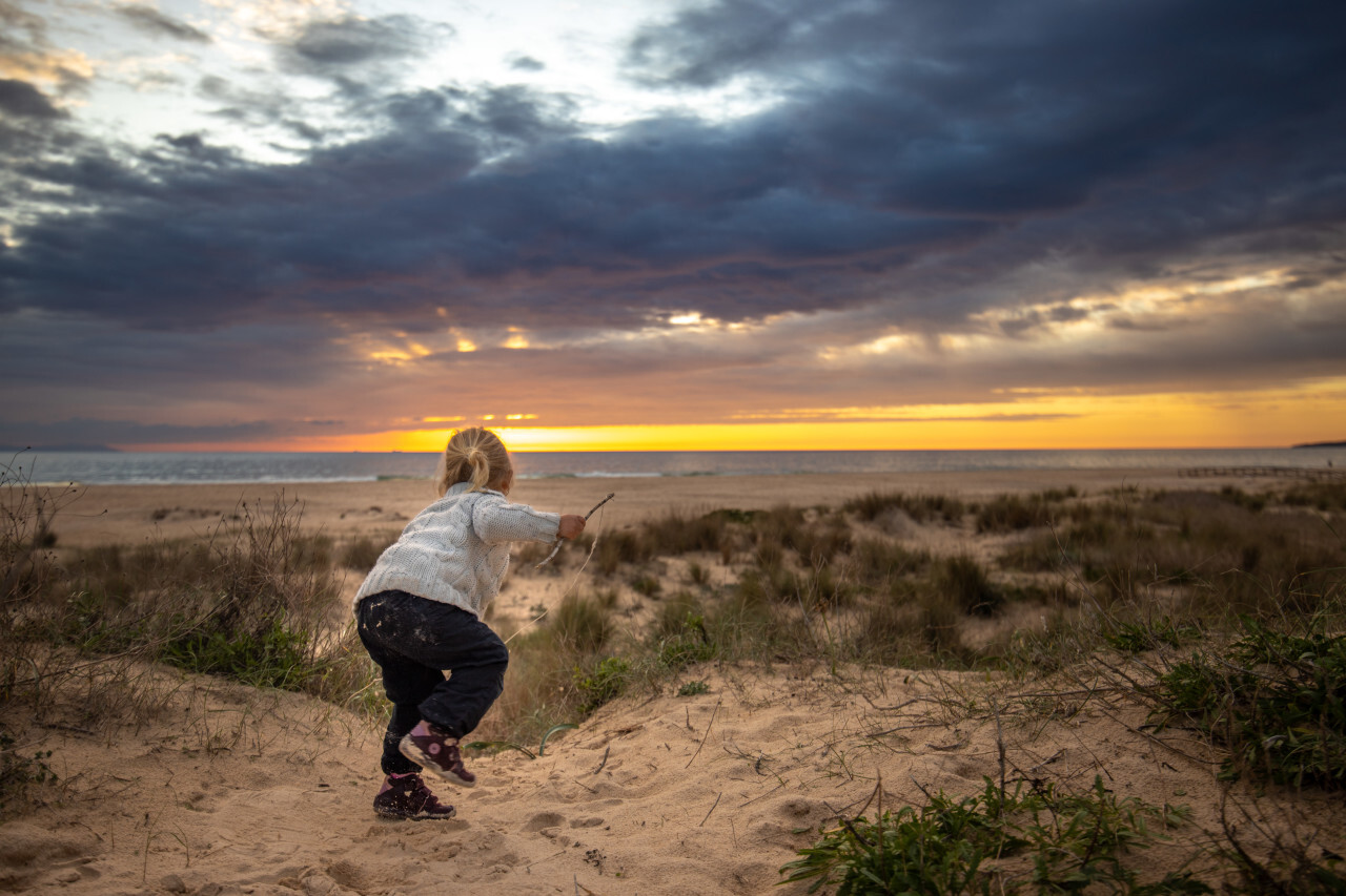 Little girl at sunset on the Spanish beach