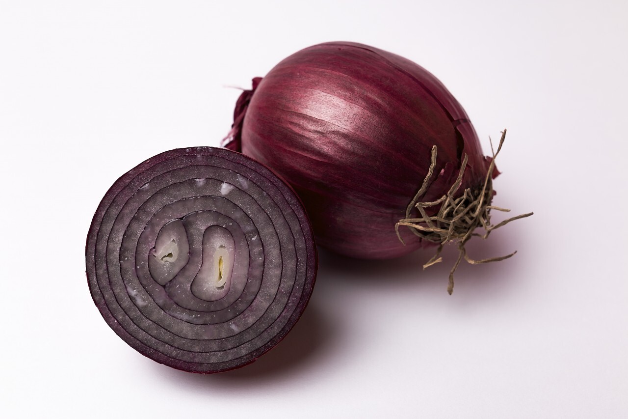 whole and sliced red onion white background