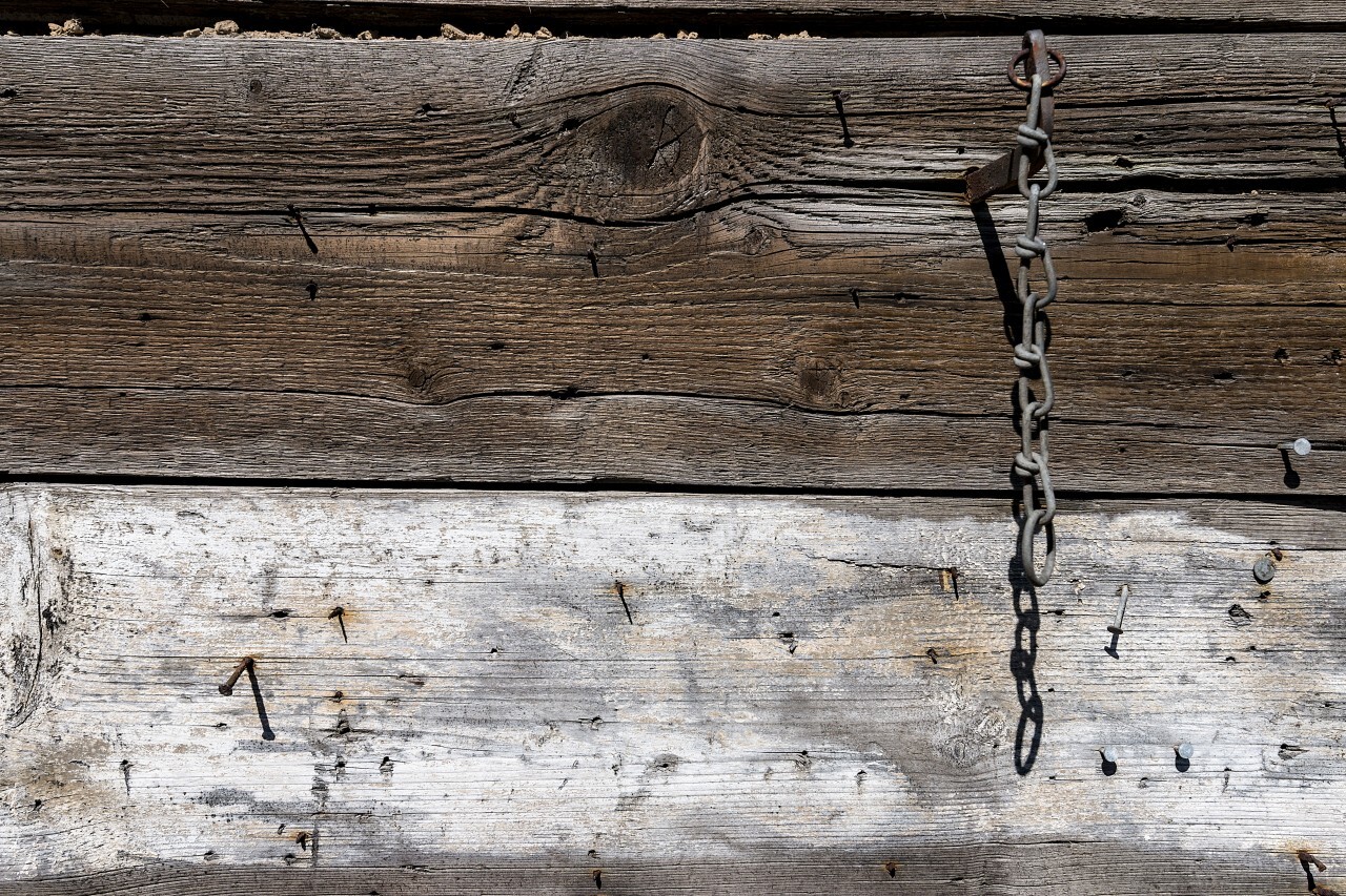 wood wall texture with rusty nails and a chain