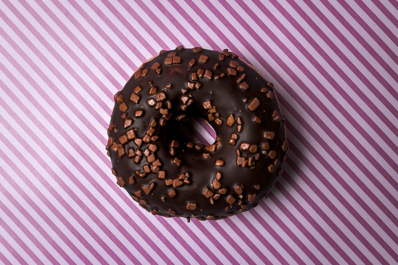 chocolate donut on pink striped background