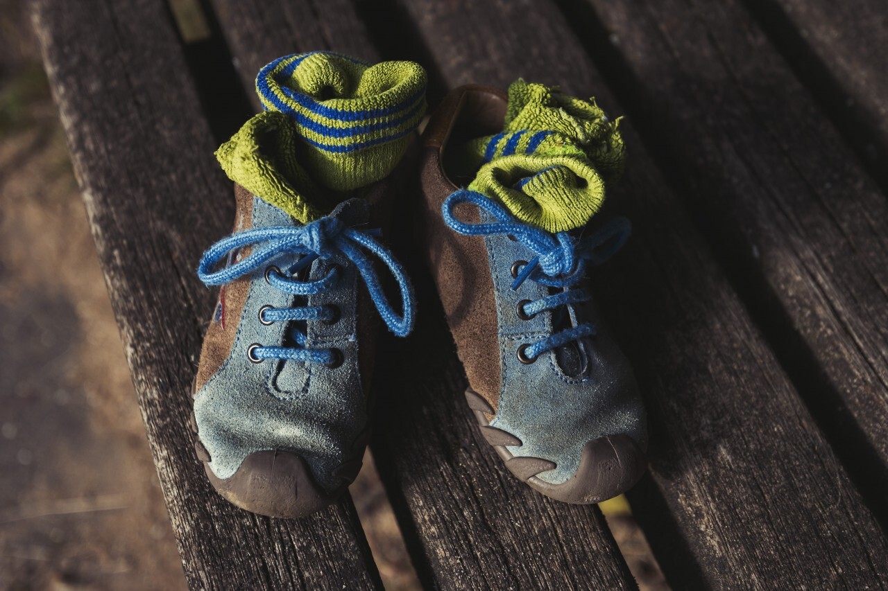 childrens shoes on a park bench topview