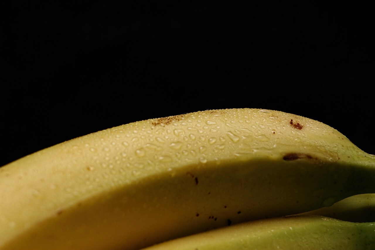 ripe yellow bananas on black background with copy space