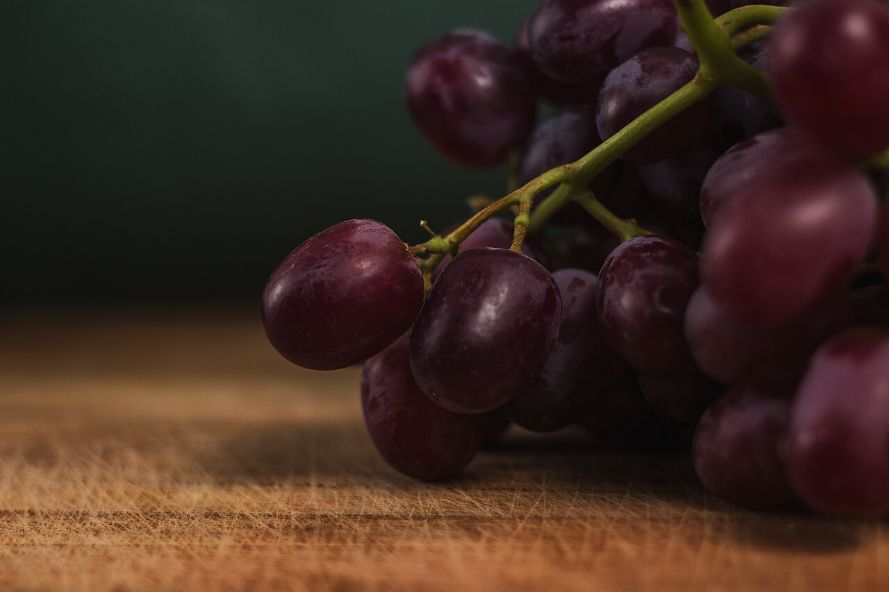red grapes on a wooden board in a kitchen