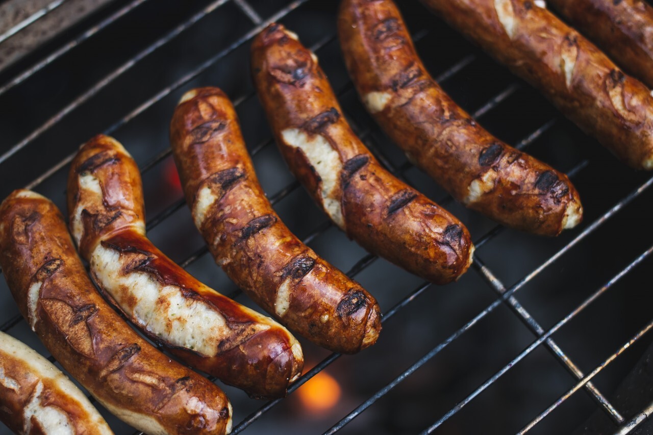 Grilling sausages on barbecue grill