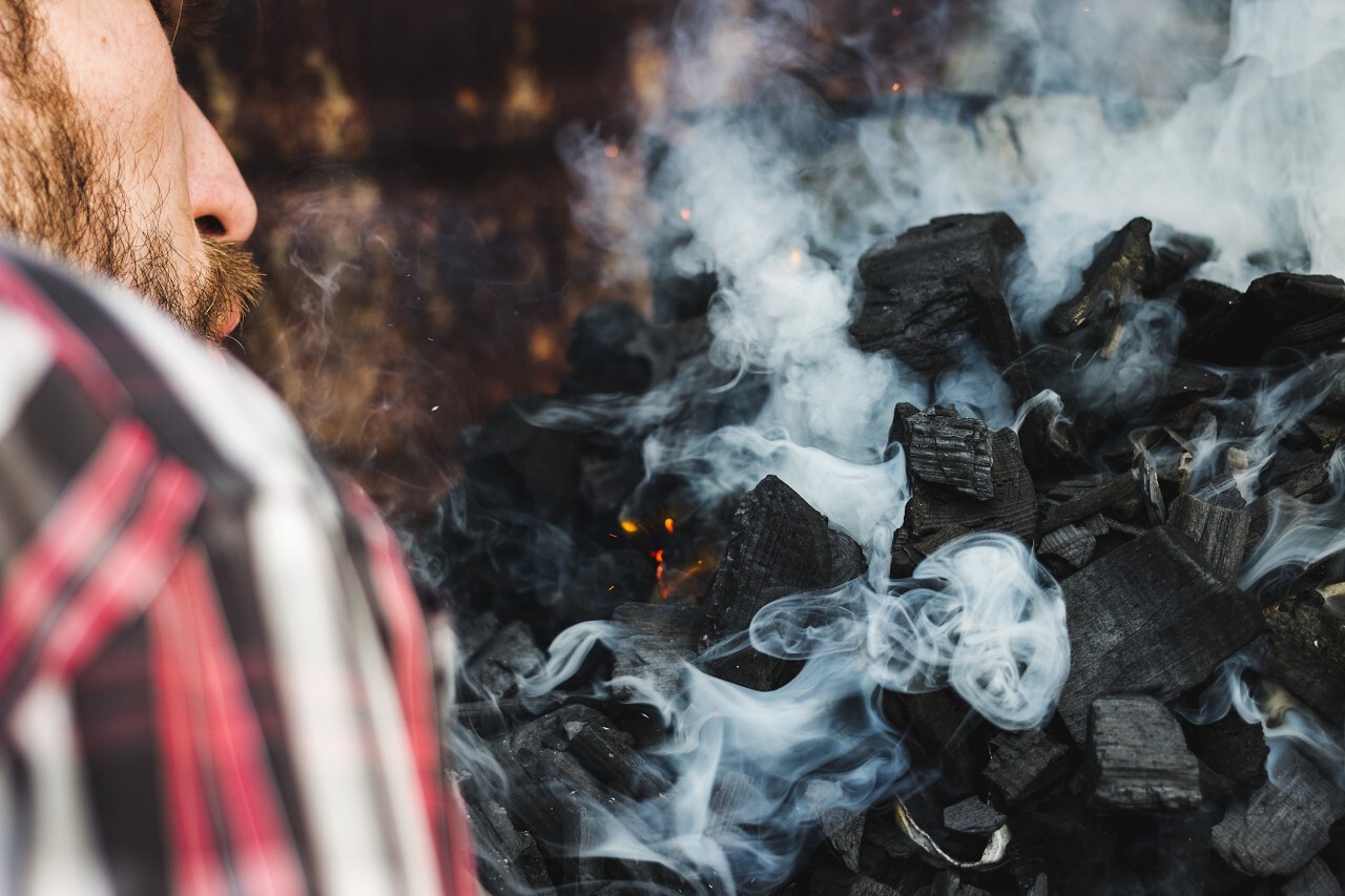 man lights barbecue