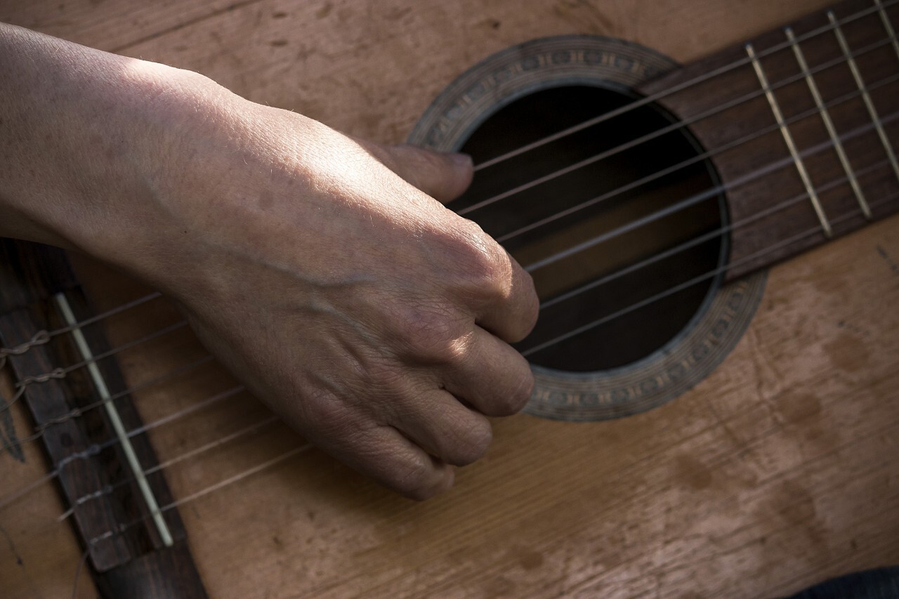 Hand playing on acoustic guitar