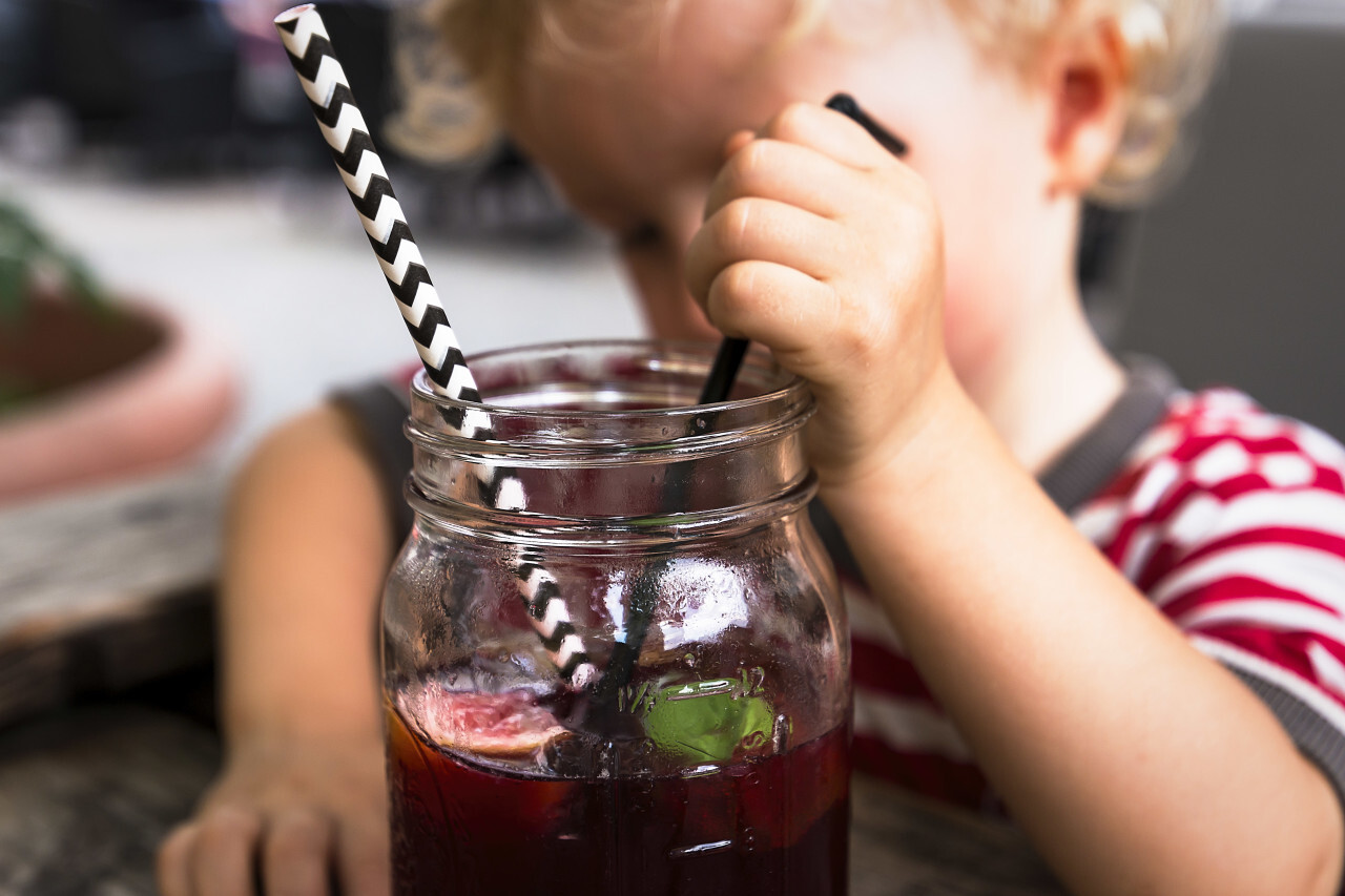 child with his red ice tea